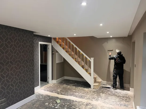 New staircase installed and a feature wall being decorated during internal alterations to a Caerphilly home